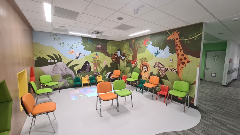 The dedicated paediatric waiting area in the new Grimsby Emergency Department has a mural of African wildlife, brightly coloured chairs, and an interactive floor