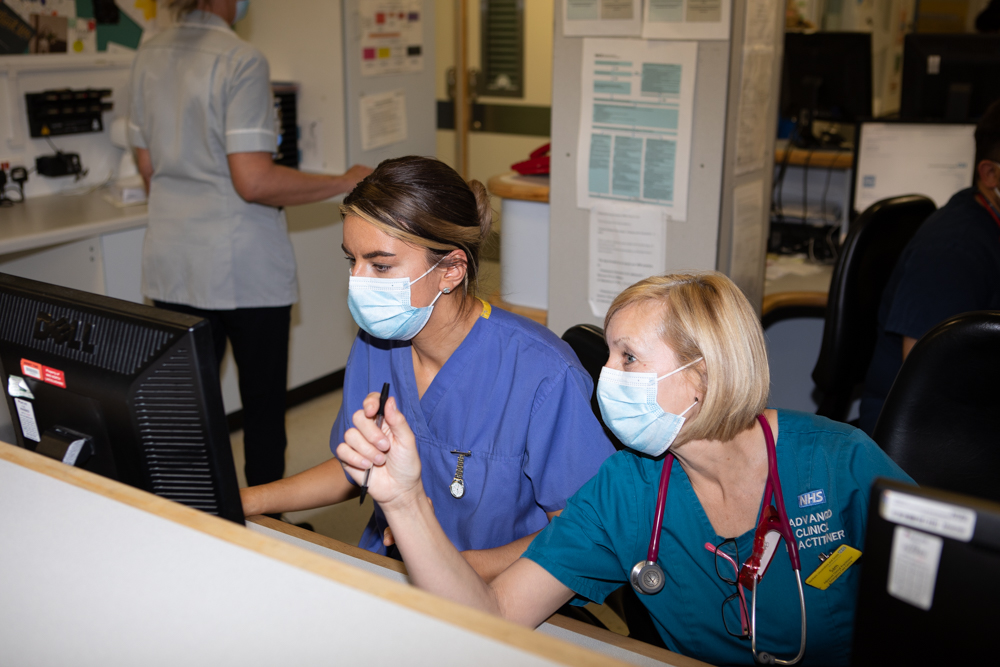 Two of our clinical staff looking at a computer screen