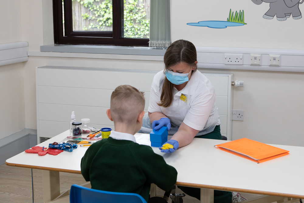 A therapist shows plastic coins to a child 