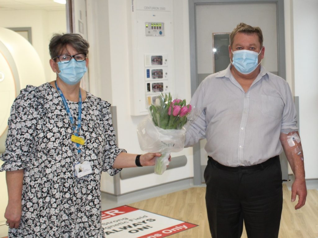 Ruth Kent, our Associate Director of Allied Health Professionals (diagnostic) hands a bouquet of flowers to our first Scunthorpe MRI patient, Andrew Barley