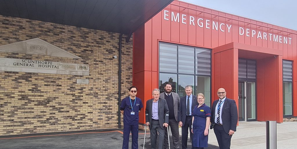 New Scunthorpe Emergency Department. Standing outside the building are Medical Director Dr Anwer Qureshi; CEO Peter Reading; Senior Project Manager for Kier Sean Hammonds, Kier Contracts Manager Peter Collins, Operational Matron Zoe Powell-Wiffen and Director of Estates and Facilities and Senior Responsible Officer for the programme, Jug Johal.