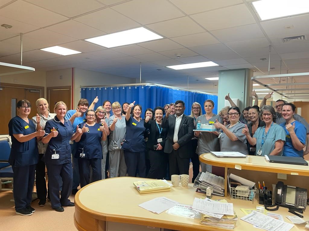 a group of staff celebrating with their hands in the air