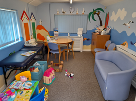 A clinic room with a sofa and toys