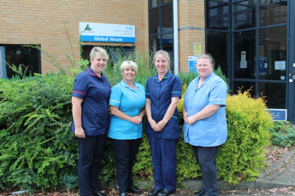 a team of nurses stood outside of a buidling