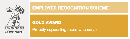 The Armed Forces Covenant Employer Recognition Scheme Gold Award logo. A lion waves the Union Flag, alongside a crown on a silver background. The rest of the logo is coloured gold.