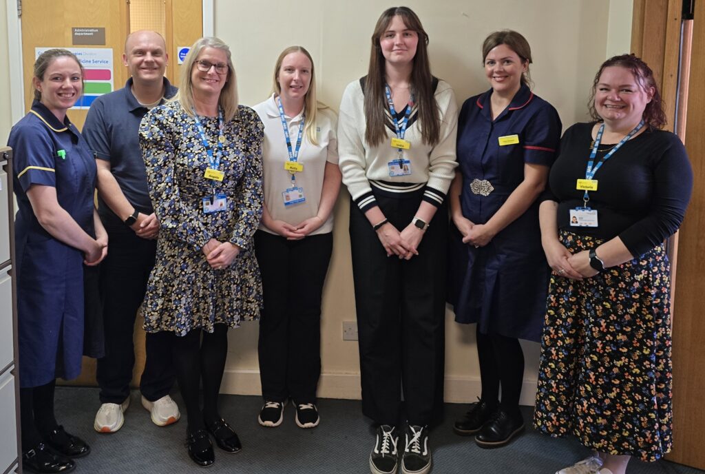 A group of women smiling. Some are wearing nursing uniforms