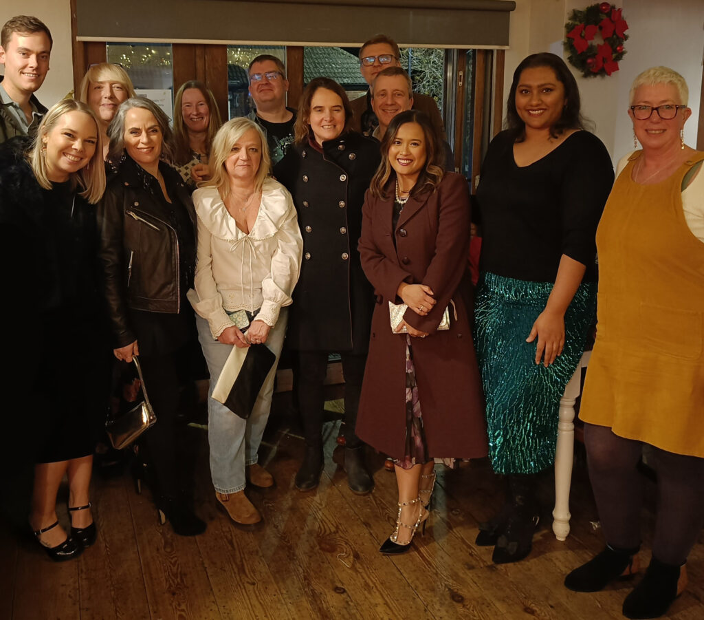 A group of people stood in a room smiling