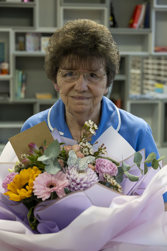 A nurse holding flowers