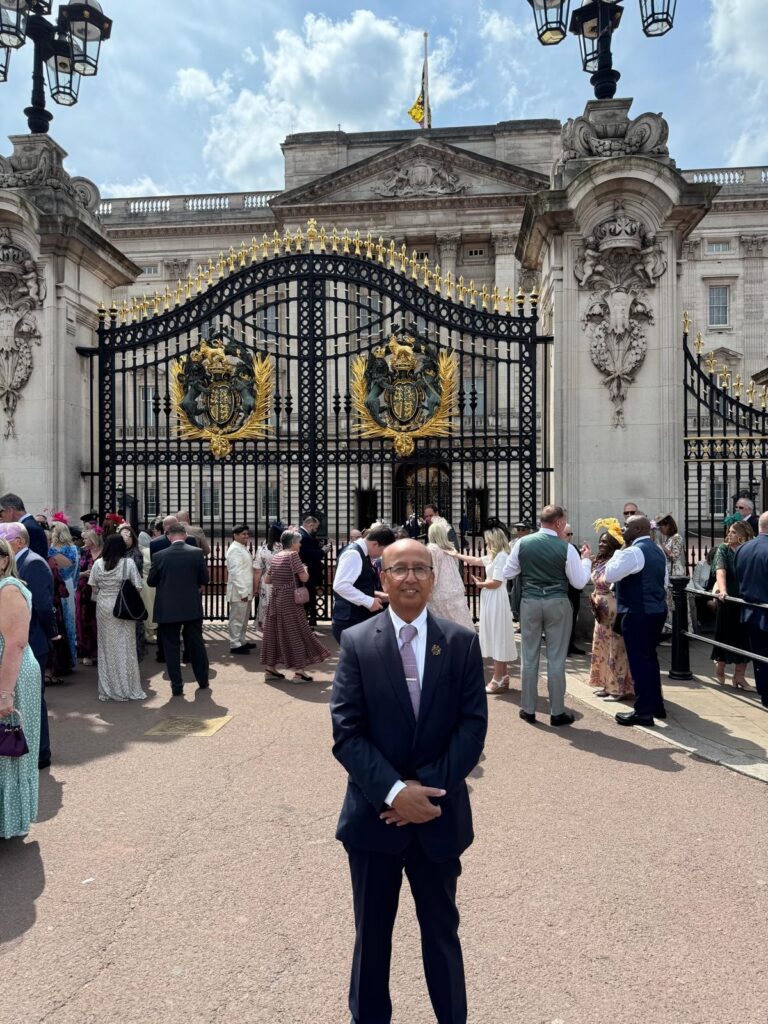 Professor Ahmed standing in front of Buckingham Palace