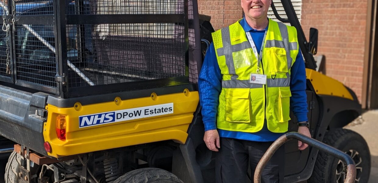 Volunteer David Sparks stands next to one of the Estates team vehicles and his litter picking barrow.
