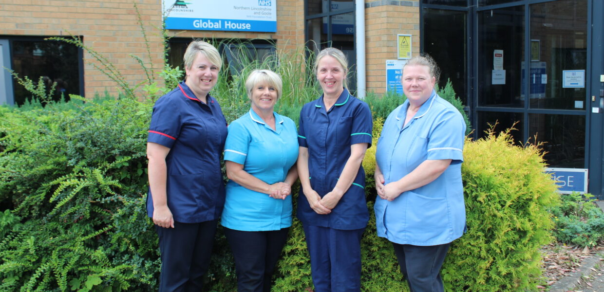 a team of nurses stood outside of a buidling
