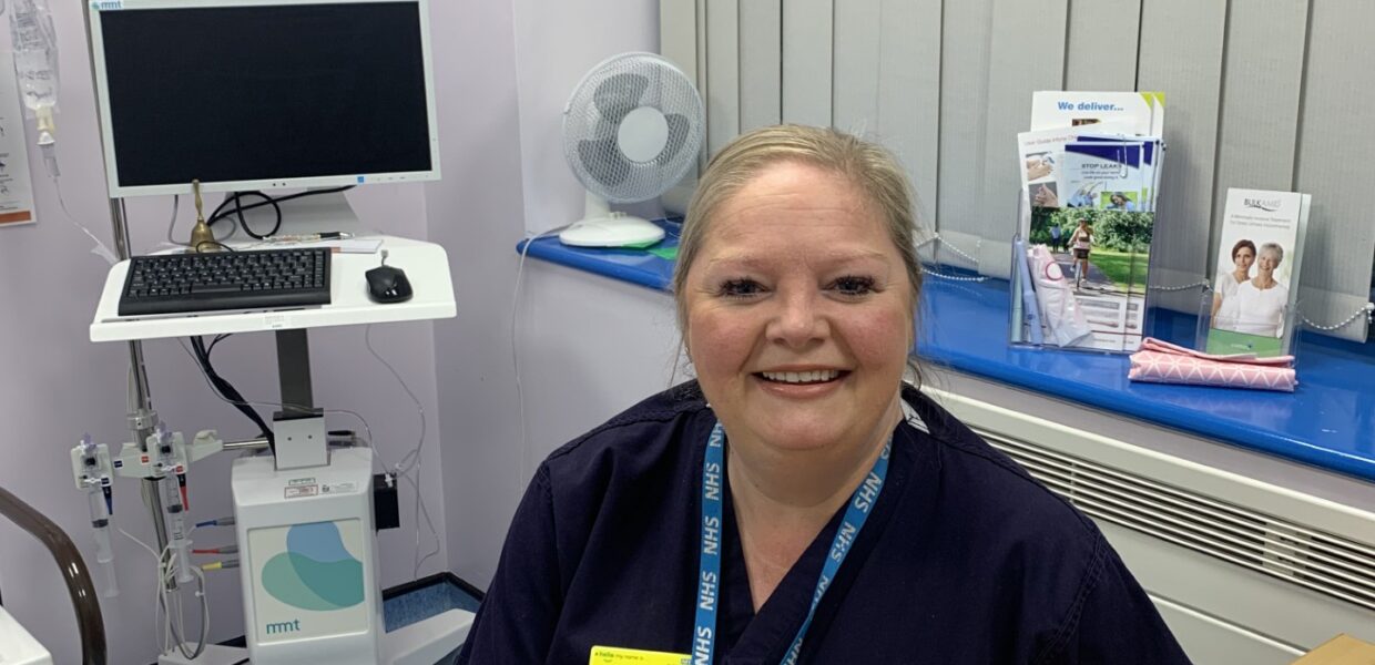 Laura Rimmer sits at her desk in front of her equipment