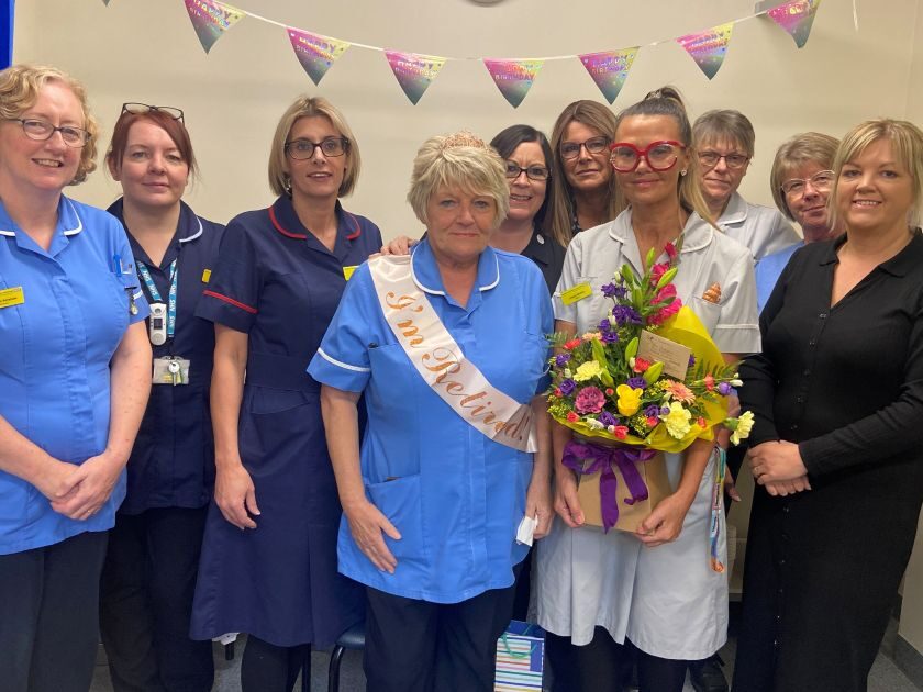 A group of nurses and healthcare staff with one of them with a sash on with says retired.