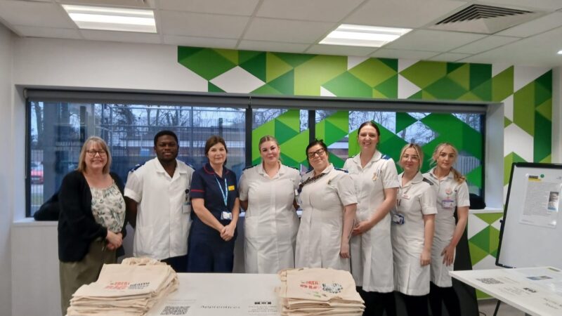 A group of NHS staff stood in front of a table