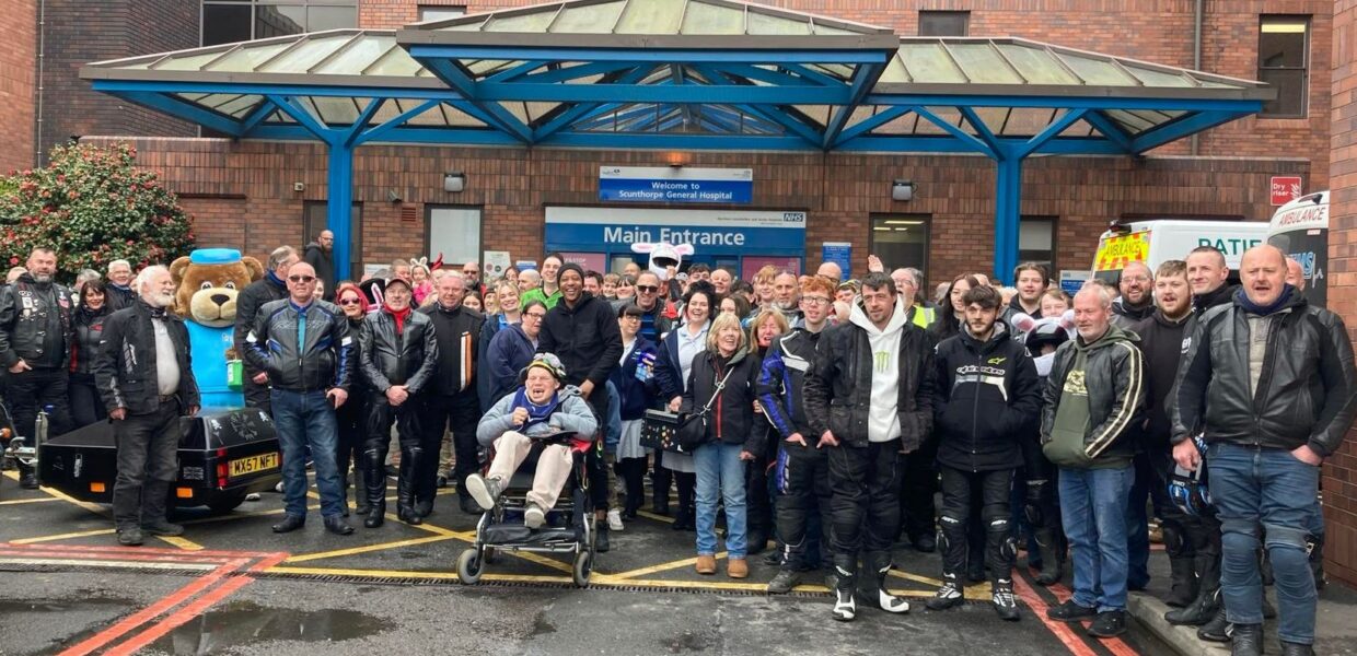 A group of people stood in front of a hospital