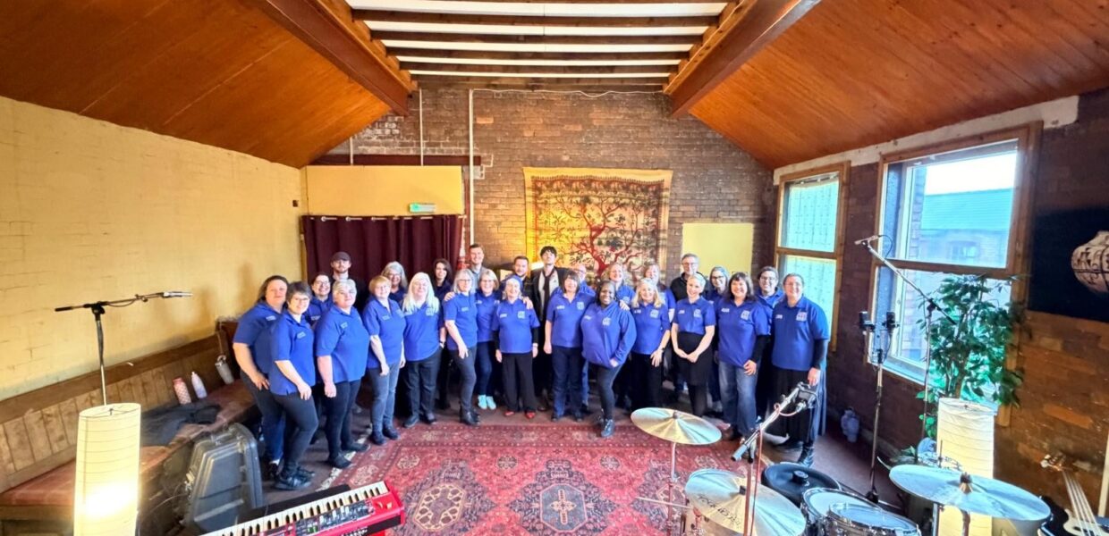 Members of the Hull NHS Choir standing in a recording studio with Sam Scherdel