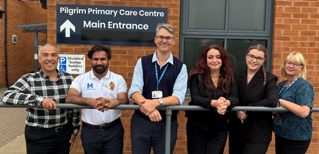 A group of NHS staff stood in front of a building