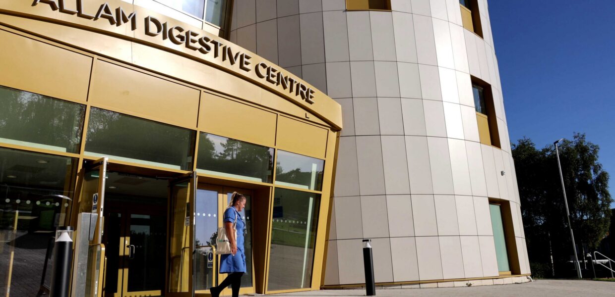 Exterior picture of a nurse walking outside the Allam Digestive Centre