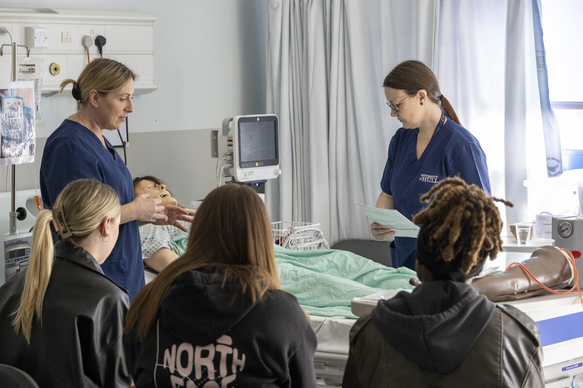 Staff stand round a "patient's bed" during a simulation exercise at the Springboard to Midwifery event