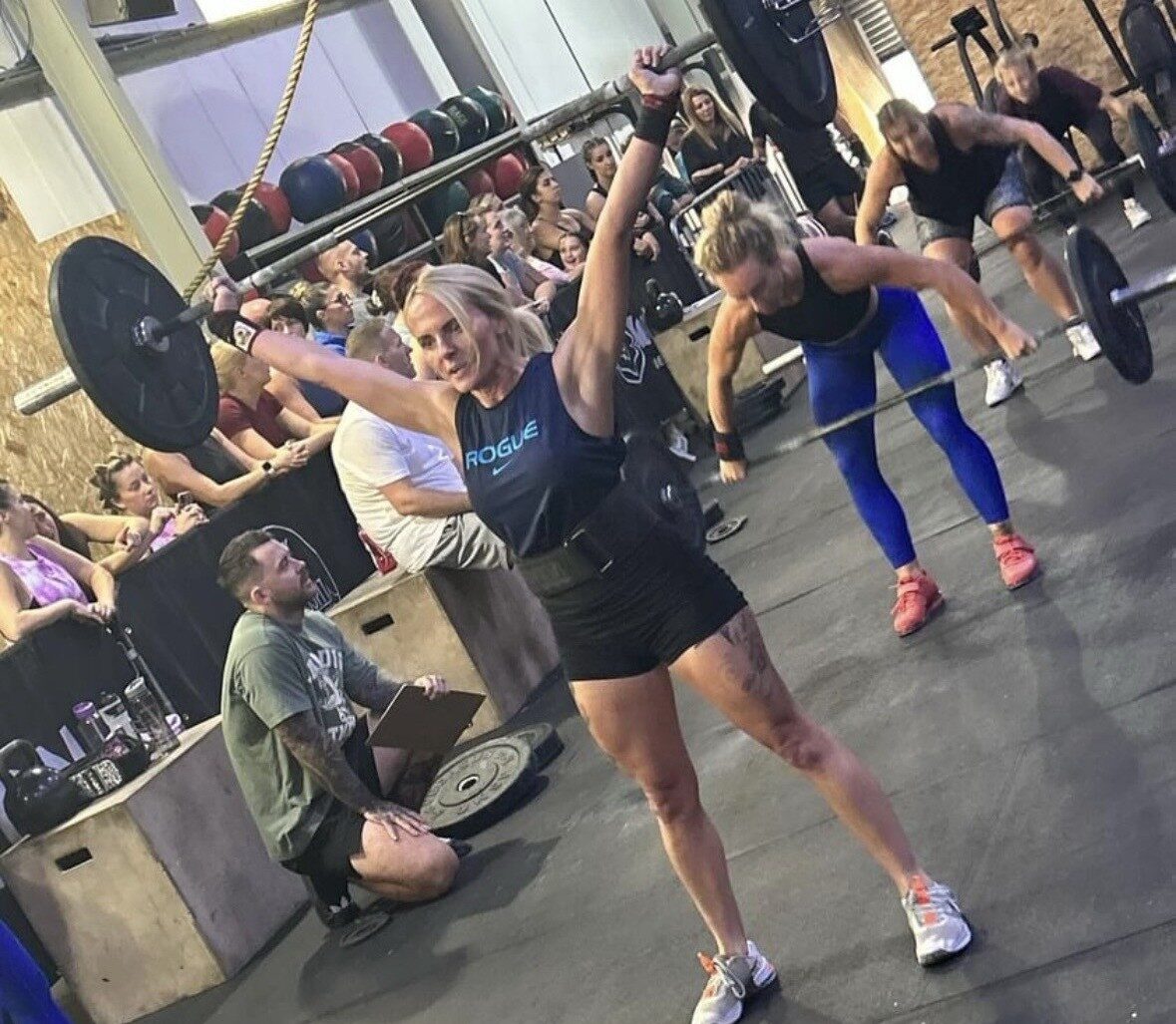 Nurse Amy Carberry lifting a barbell in a crossfit gym surrounded by people