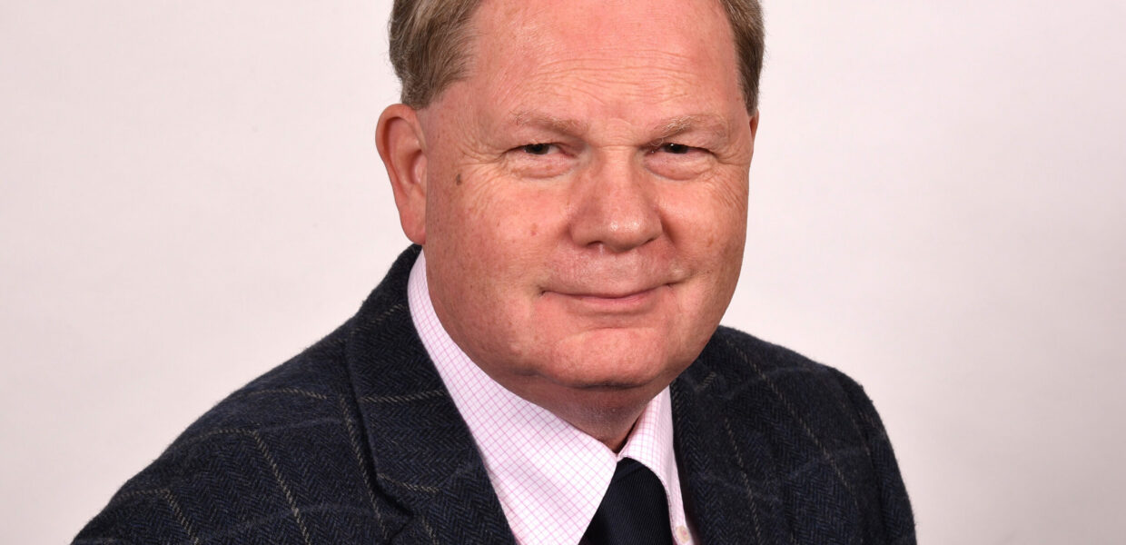 A man in a suit smiling