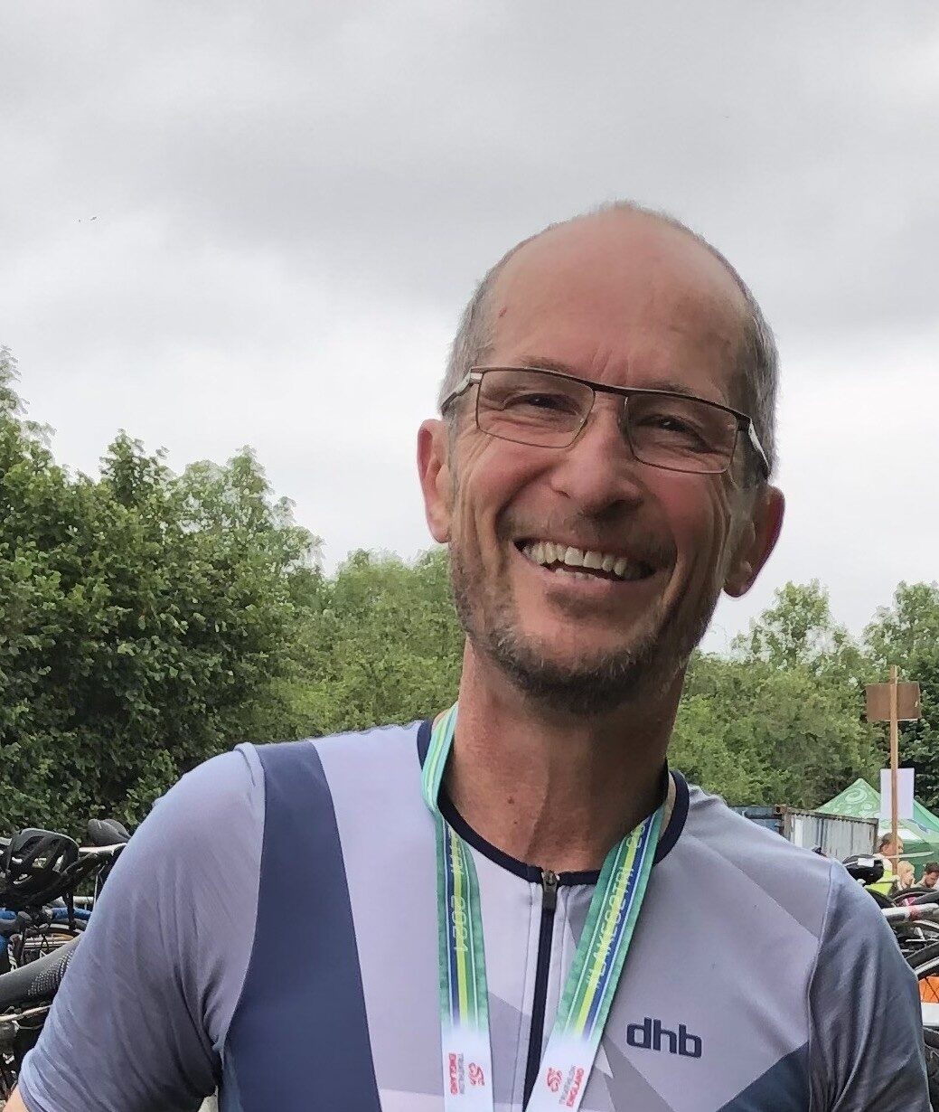 A man wearing cycling gear, smiling