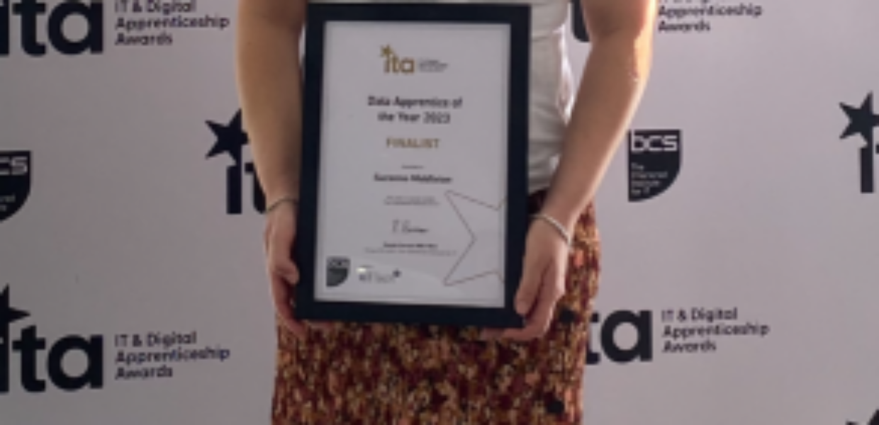 A woman is standing holding a certificate