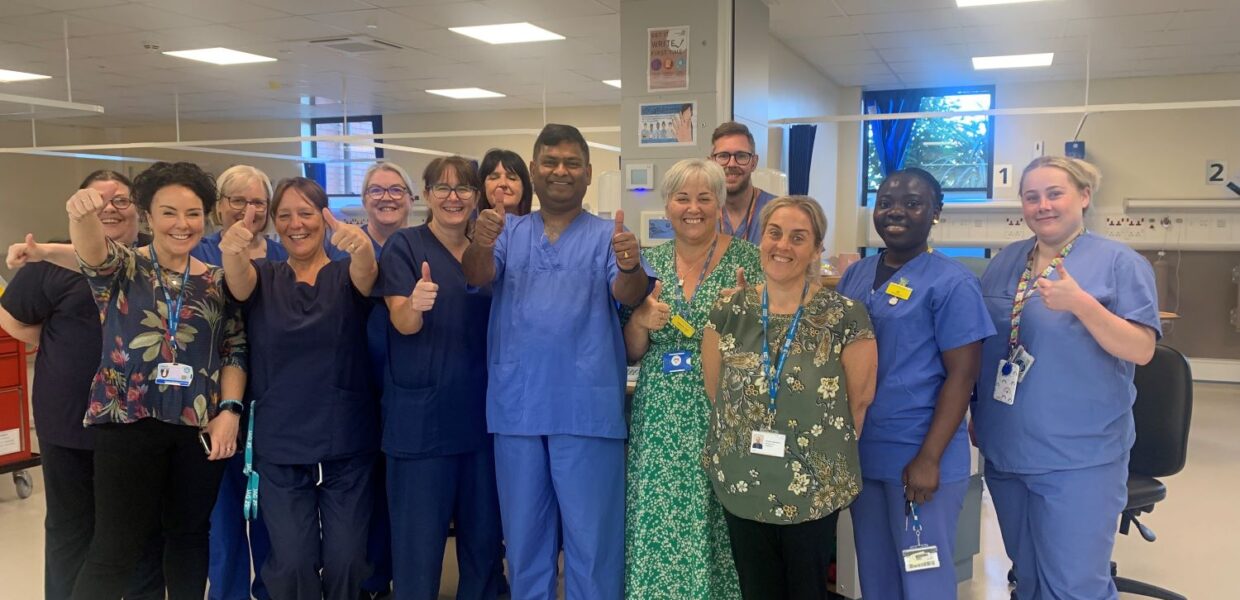 a group of staff celebrating by giving a thumbs up