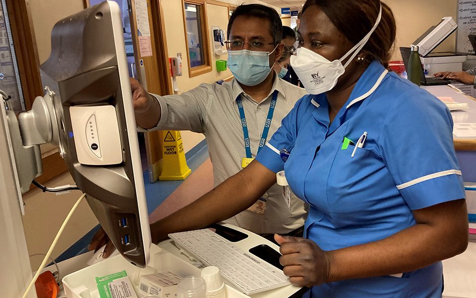 Staff using electronic prescribing and medicines administration system on a ward