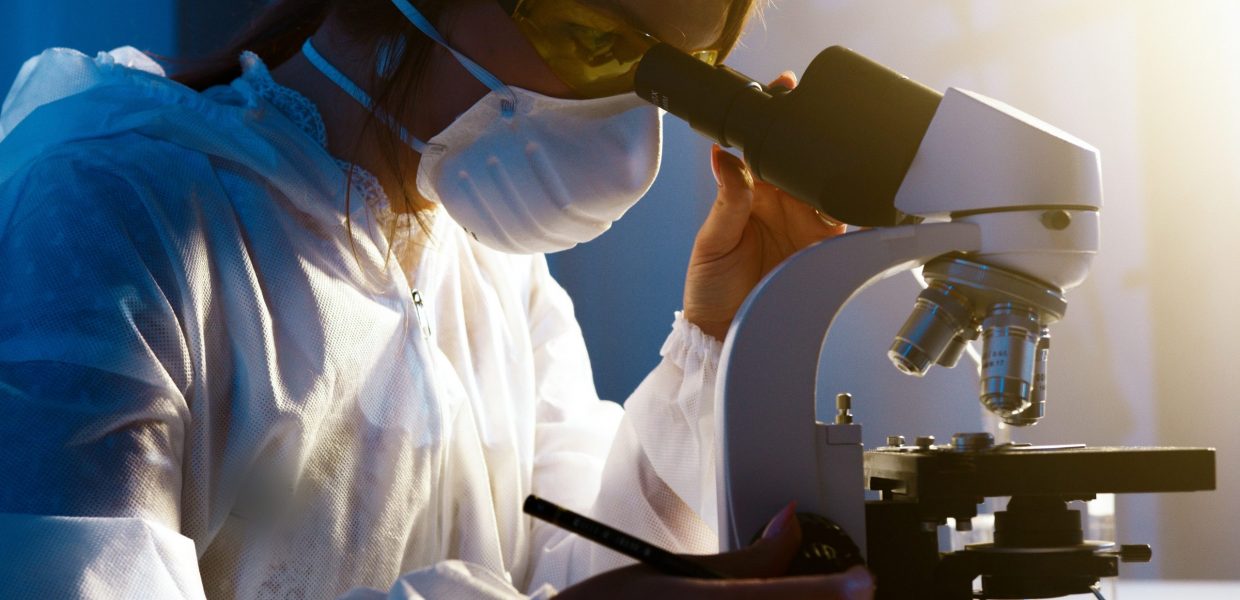 A woman looking through a microscope