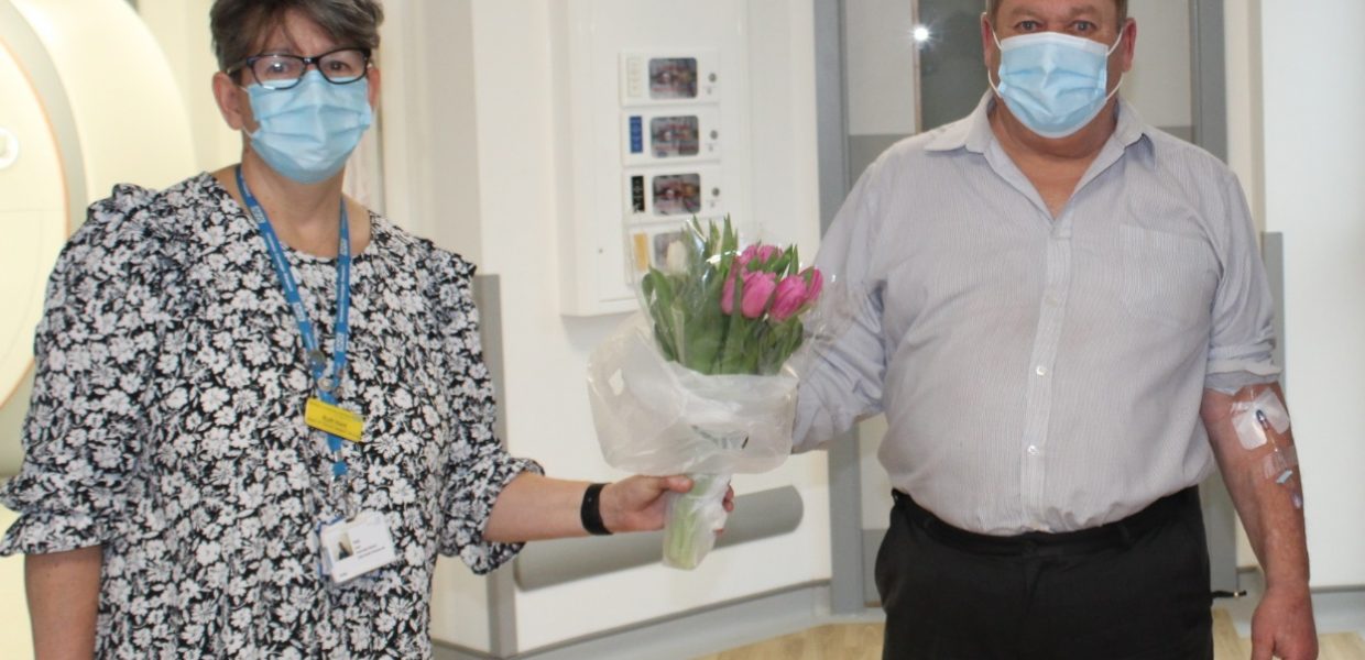 Ruth Kent, our Associate Director of Allied Health Professionals (diagnostic) hands a bouquet of flowers to our first Scunthorpe MRI patient, Andrew Barley