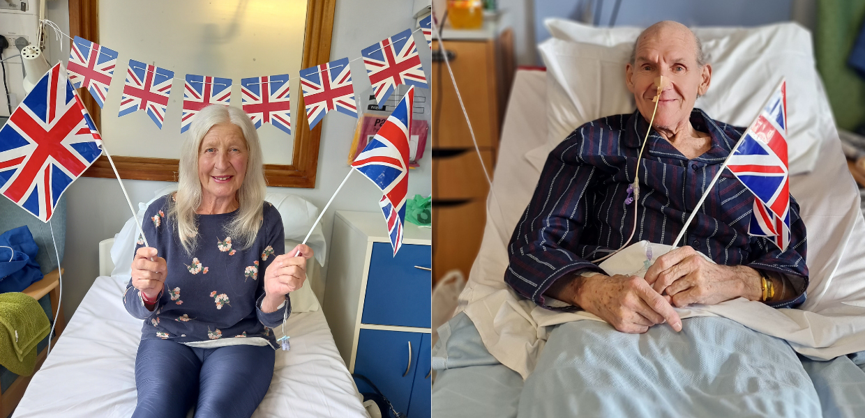 Patient Elaine and Barrie in their hospital beds waving British flags