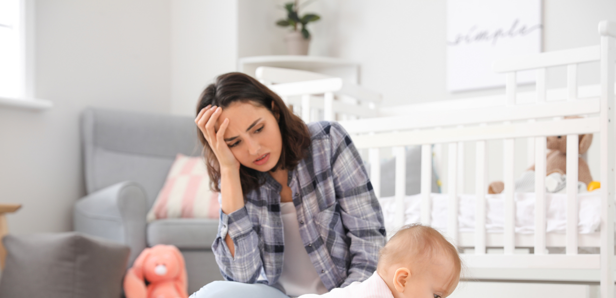 Perinatal mental health is important: A mum looks anxious/ frustrated as she watches her baby play