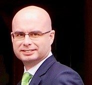A man in a suit smiling.
